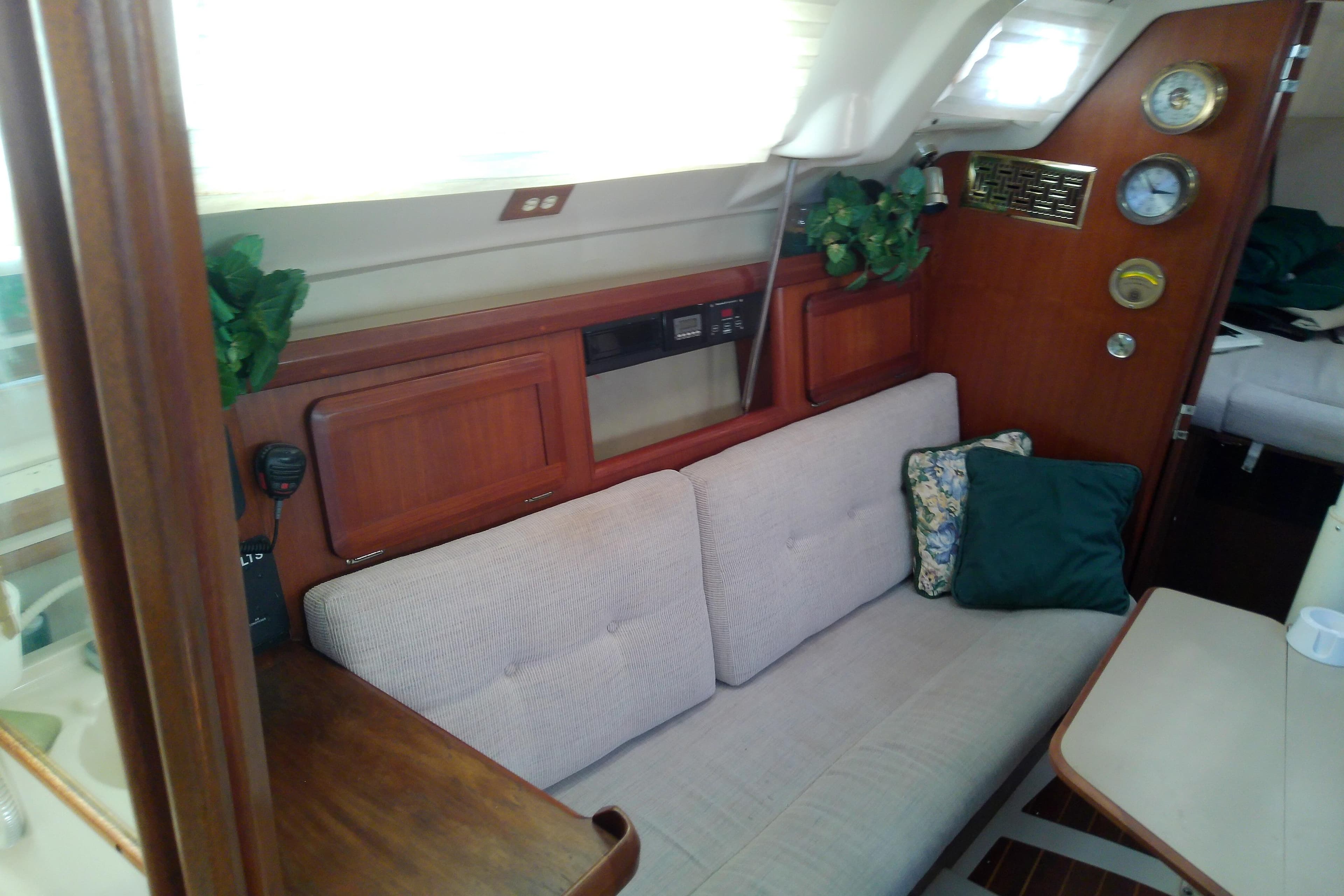 Interior of a 1991 Hunter 30 sailboat with cozy seating and nautical decor.