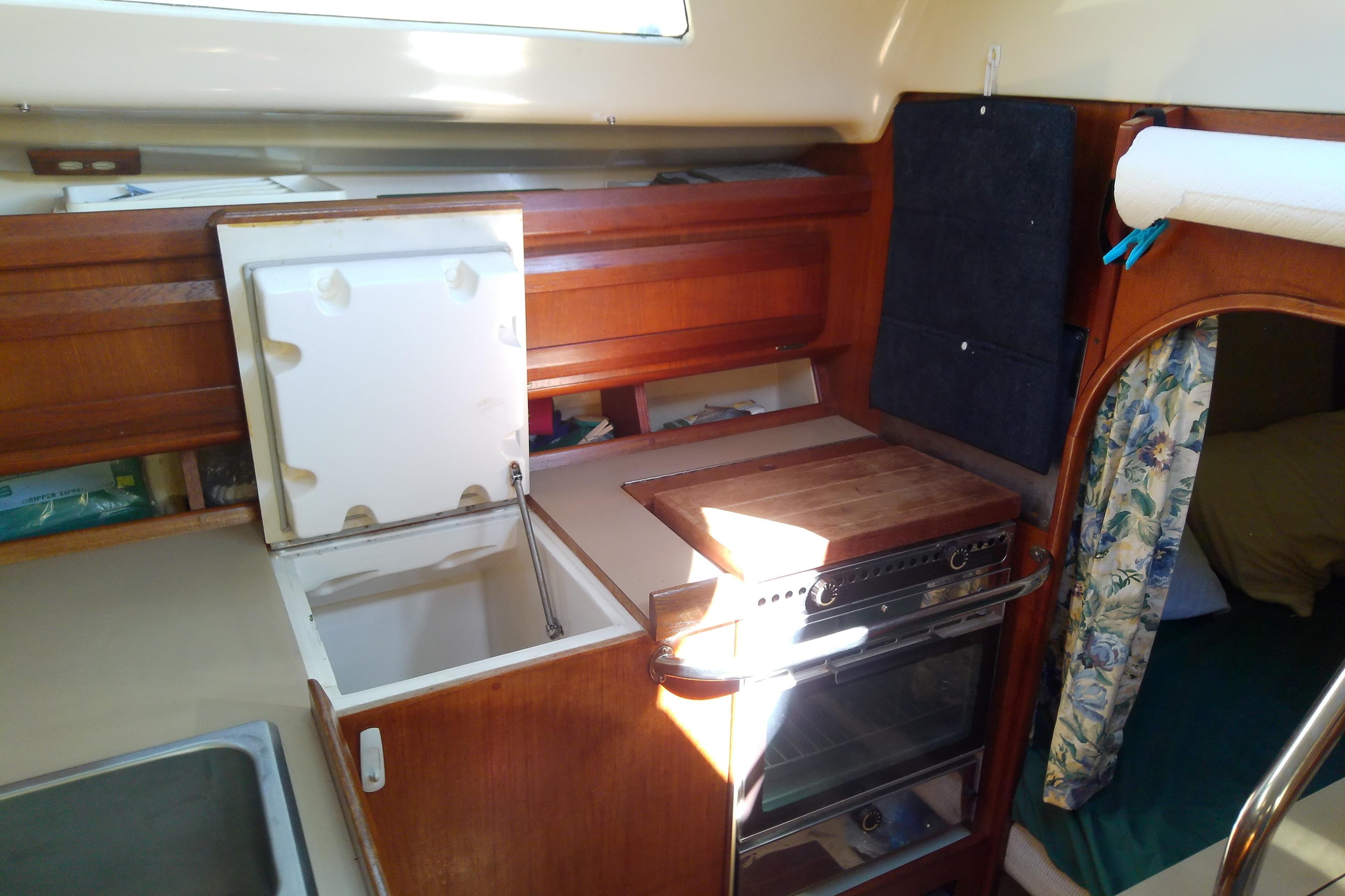 Interior of a 1991 Hunter 30 sailboat kitchen with stove and storage.