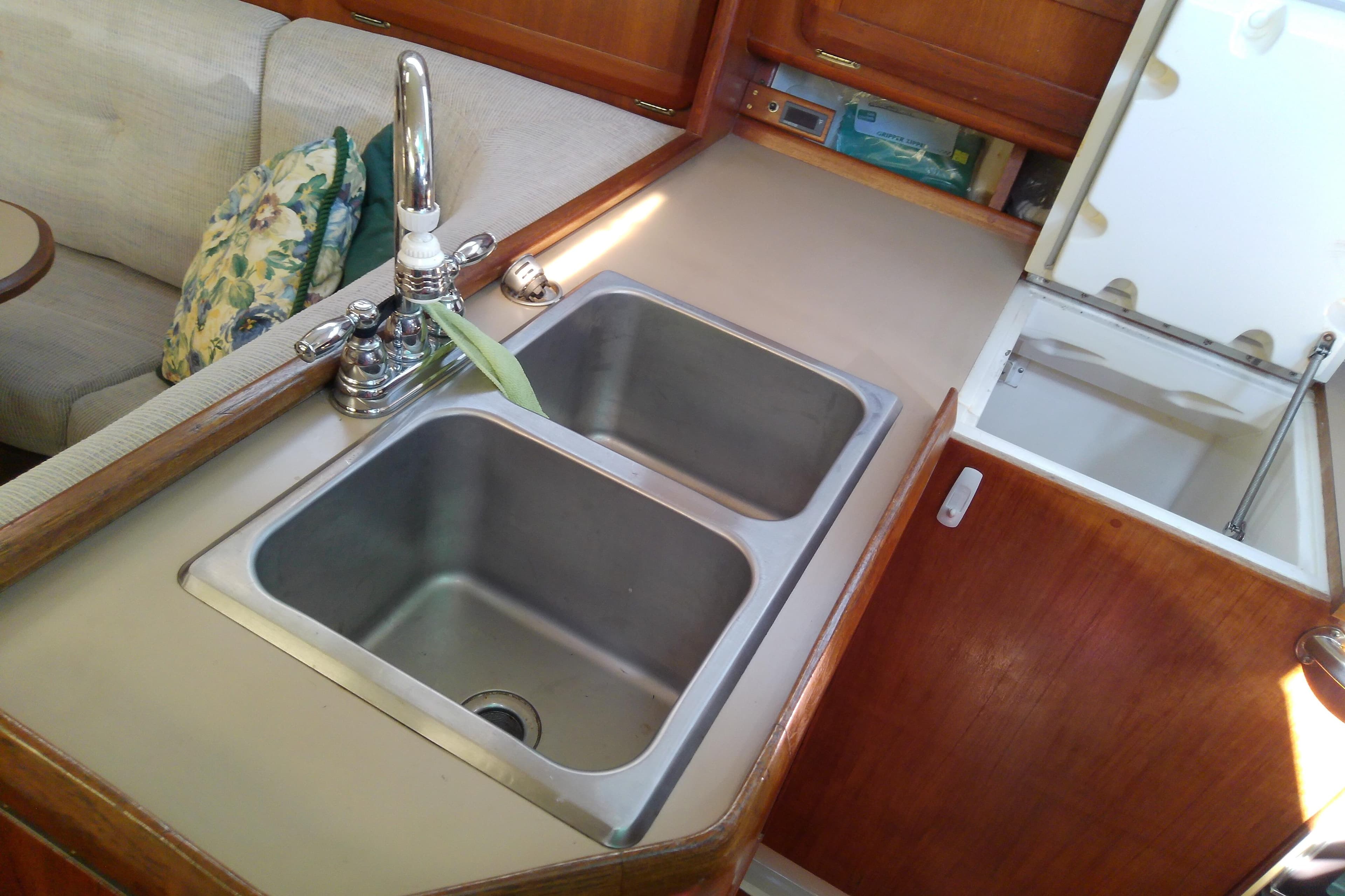 1991 Hunter 30 yacht kitchen with double sink and wooden cabinetry.