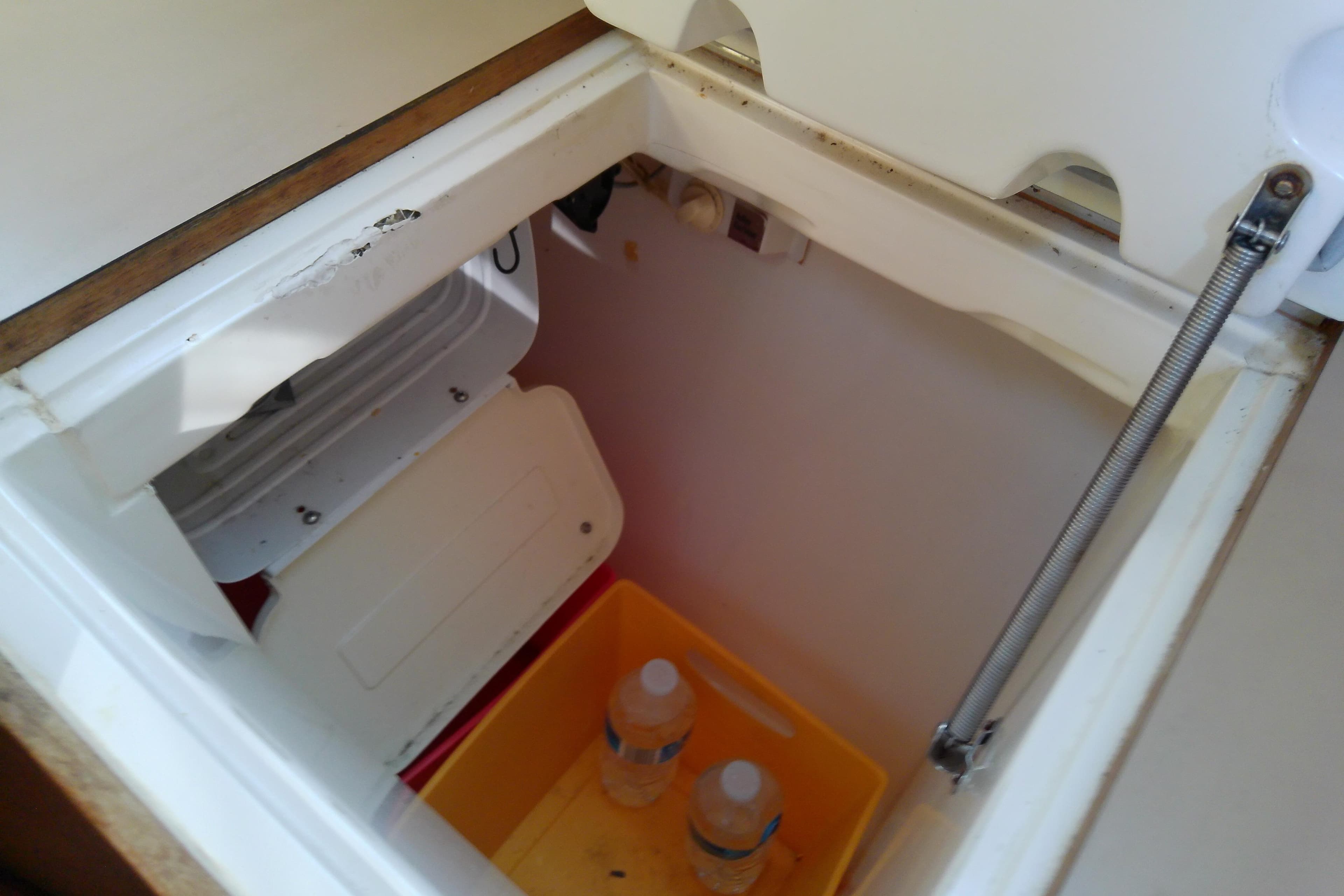 Storage compartment with water bottles in a 1991 Hunter 30 sailboat.