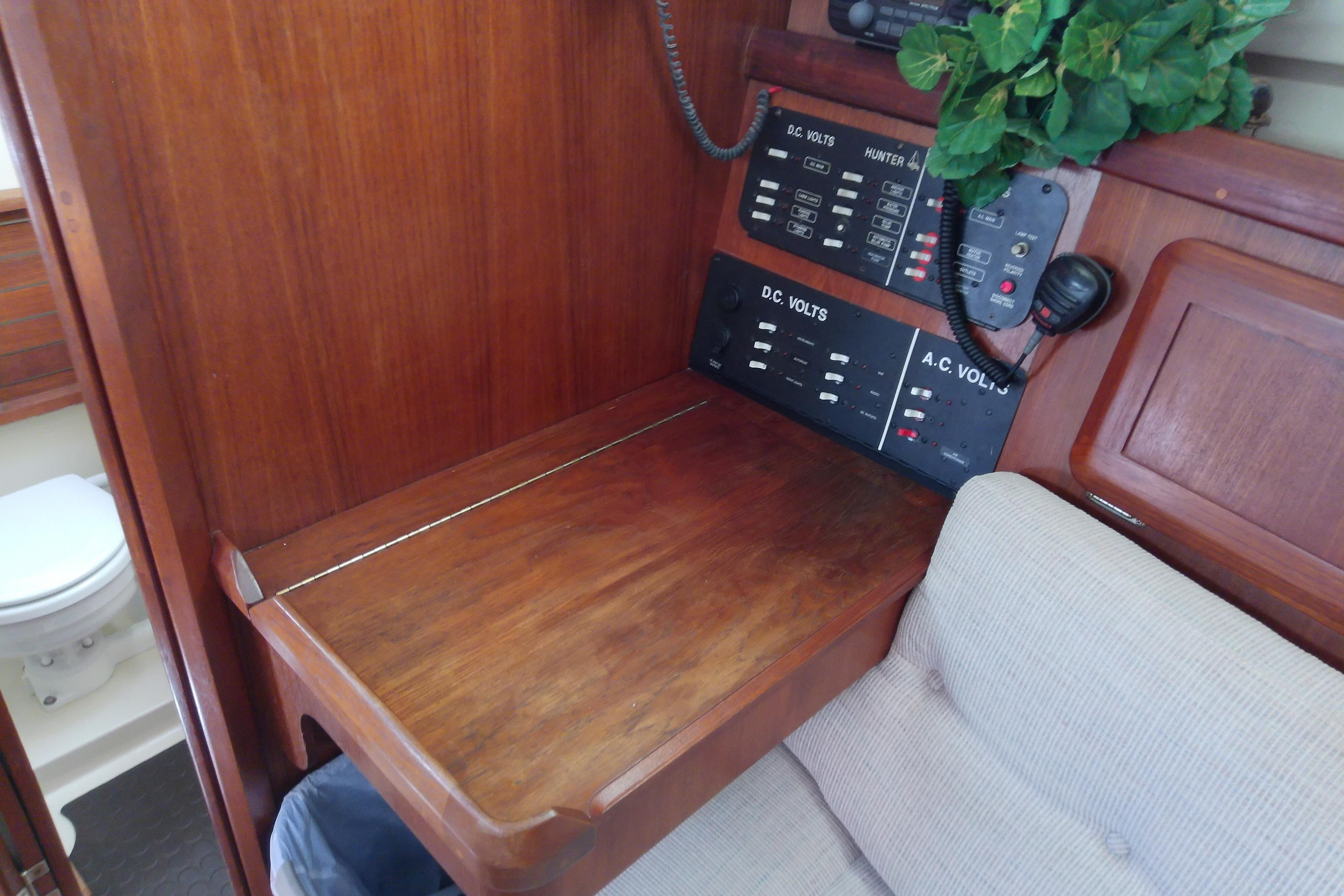 Interior of a 1991 Hunter 30 sailboat with control panels and wooden desk.