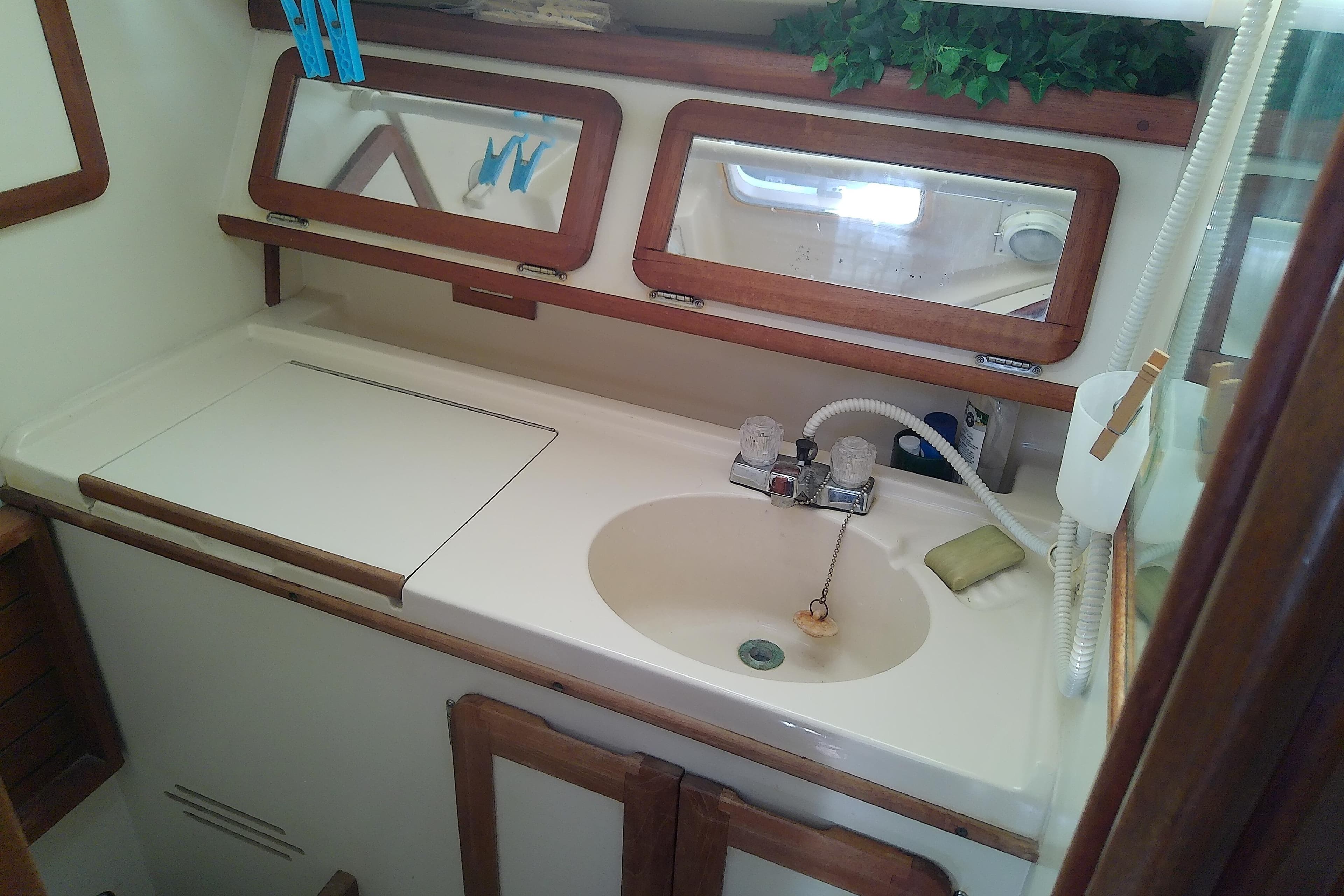 Interior of a 1991 Hunter 30 sailboat bathroom with sink and wooden accents.