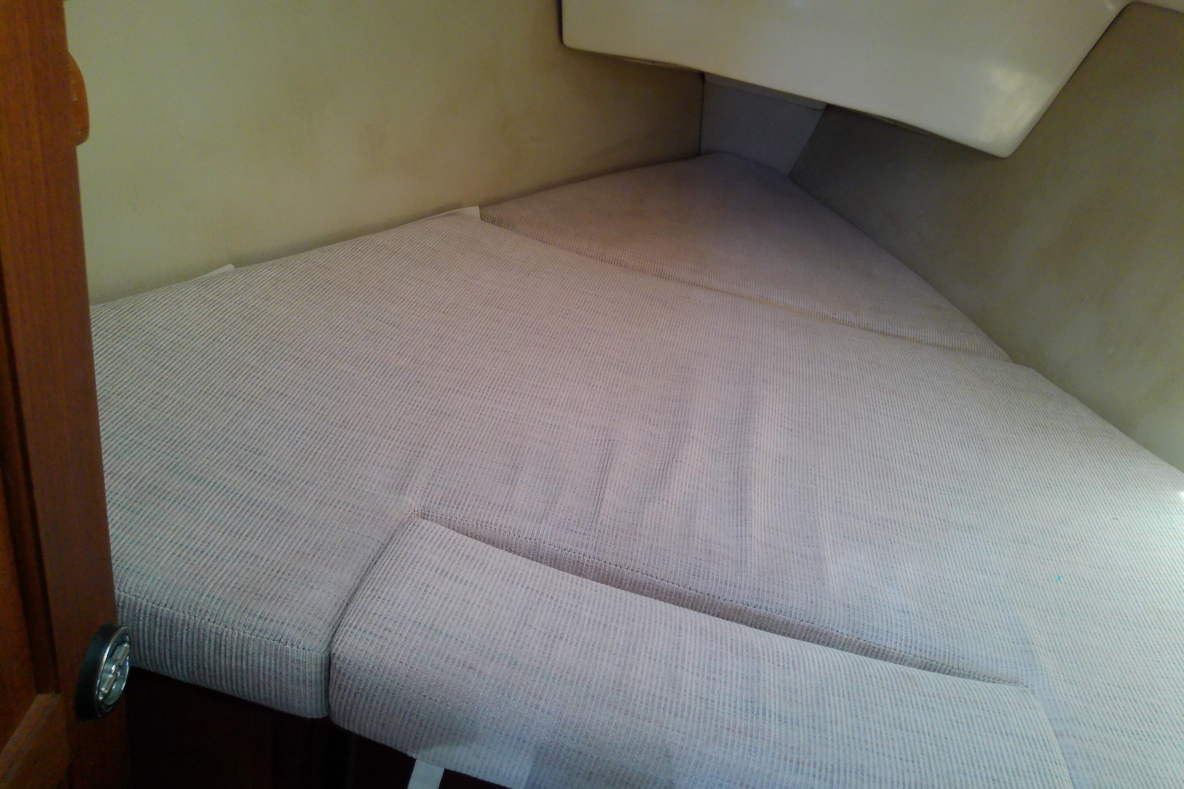 Interior cabin of a 1991 Hunter 30 sailboat with cushioned sleeping area.