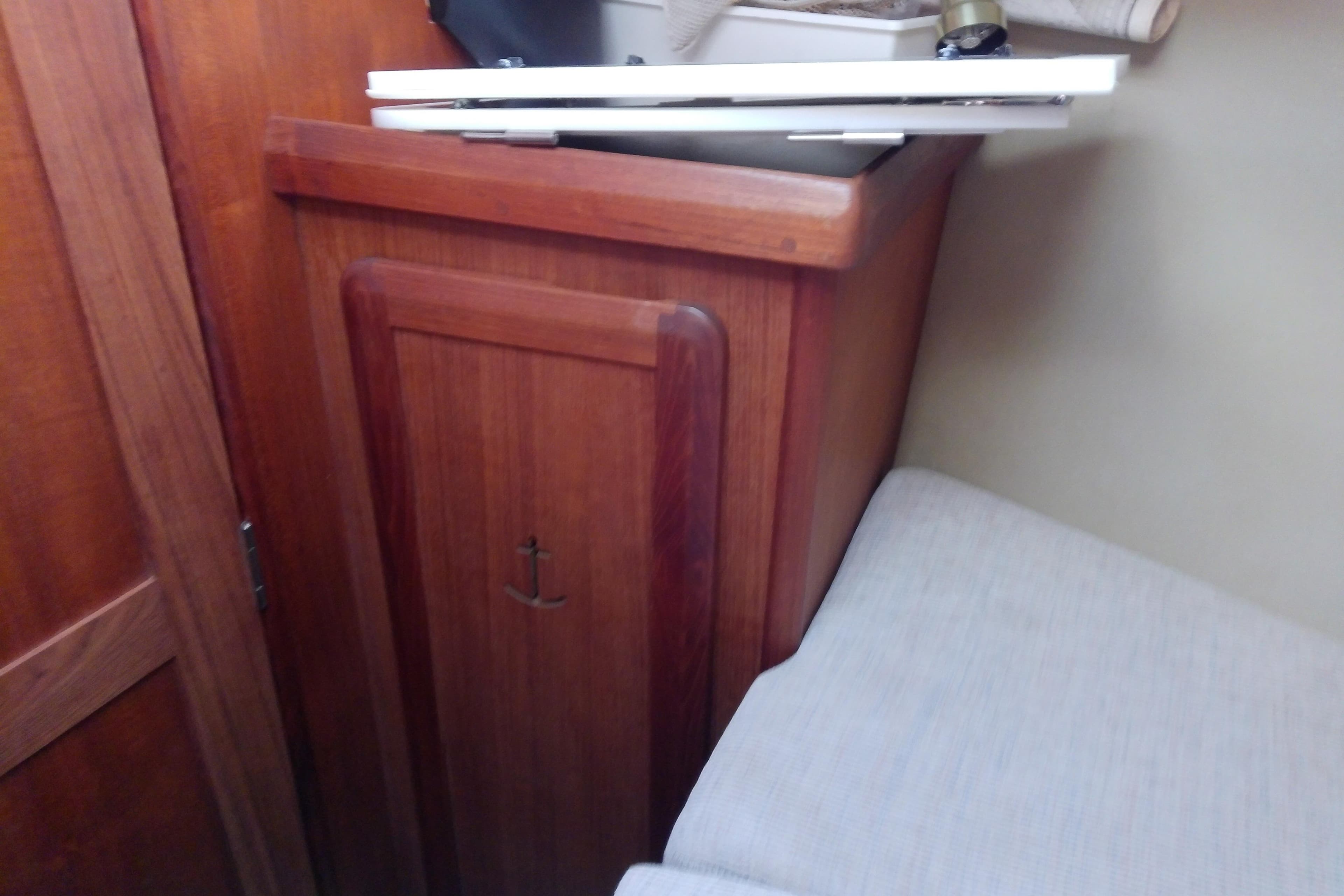 Interior of 1991 Hunter 30 sailboat with wooden cabinetry and anchor detail.