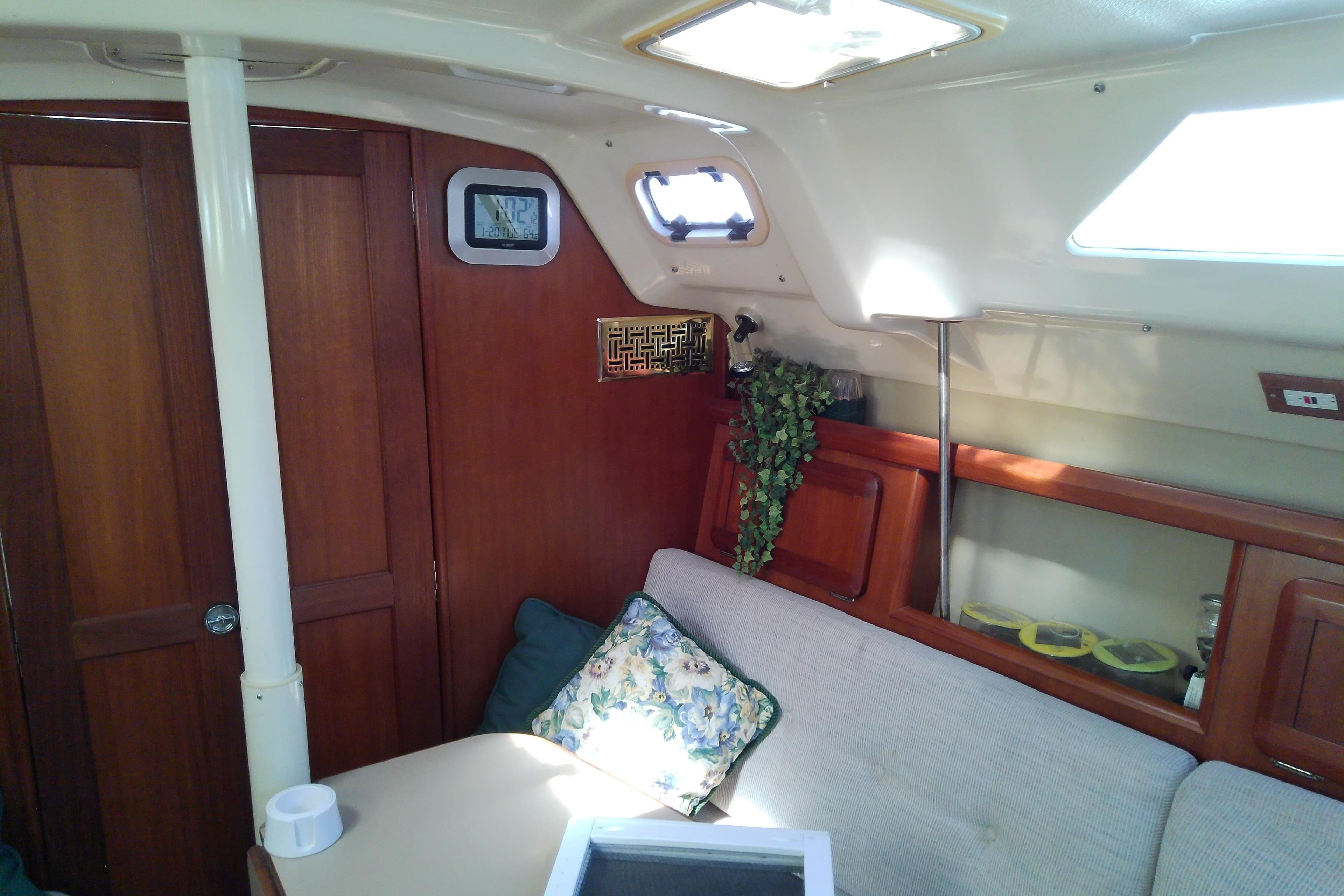 Interior of a 1991 Hunter 30 sailboat with wooden cabinetry and cozy seating area.